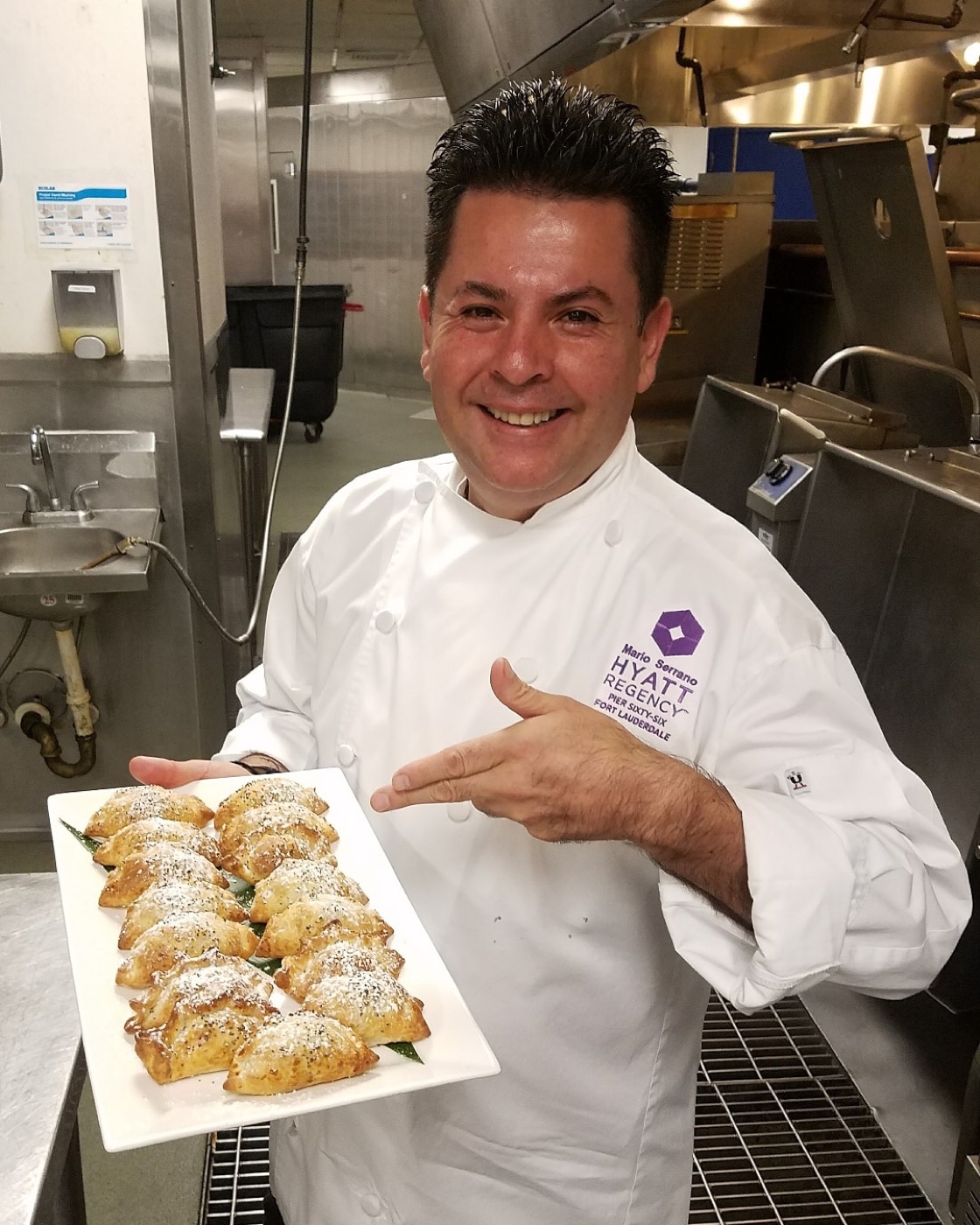 Mario Serrano, the chef behind Empanadas Gusto, holding a tray of his empanadas
