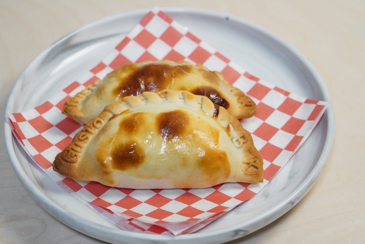 Smoked brisket empanadas on red-checkered paper